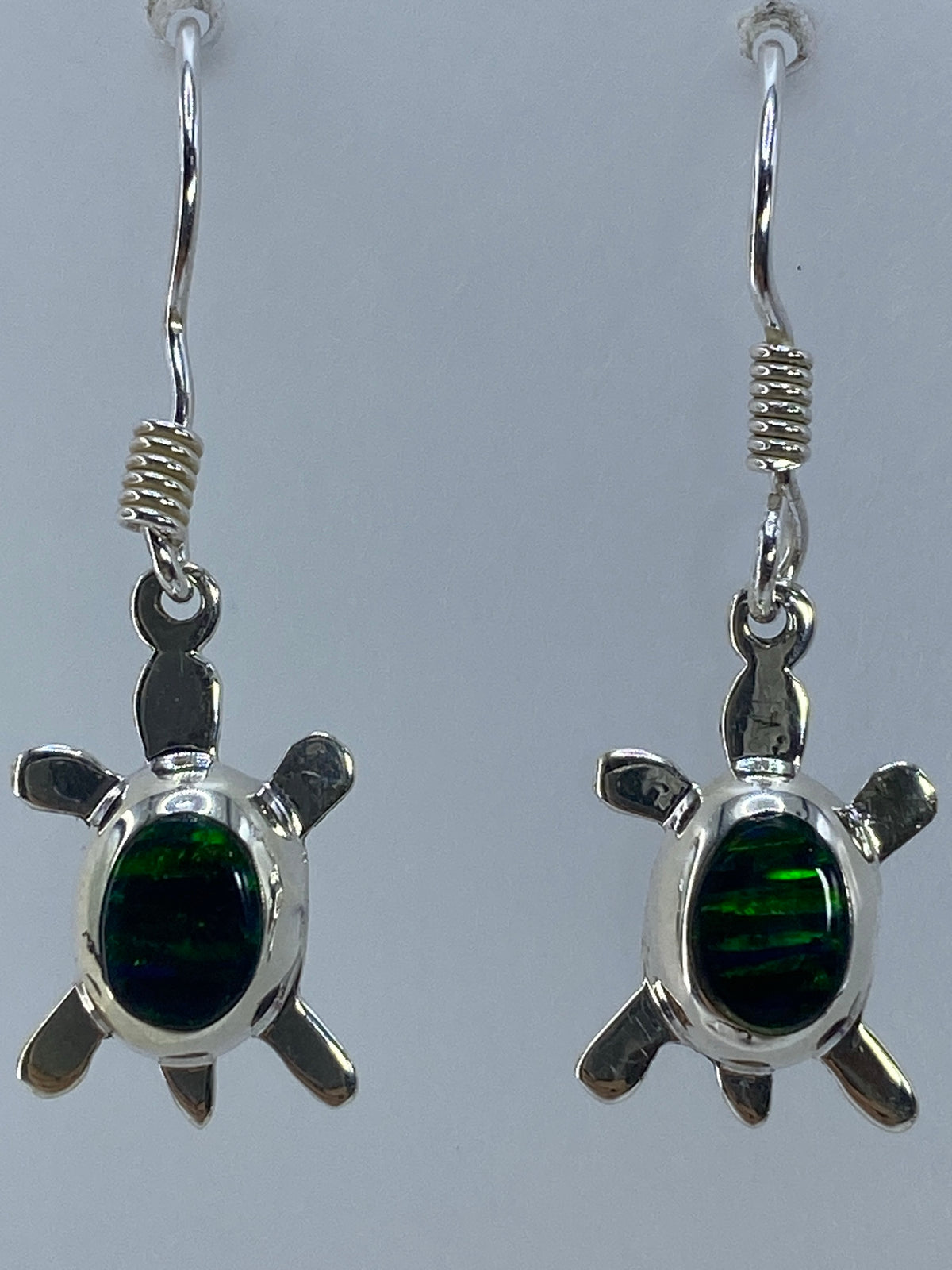 Detalle del engaste de ópalo de fuego en aretes de plata Taxco con Quinto