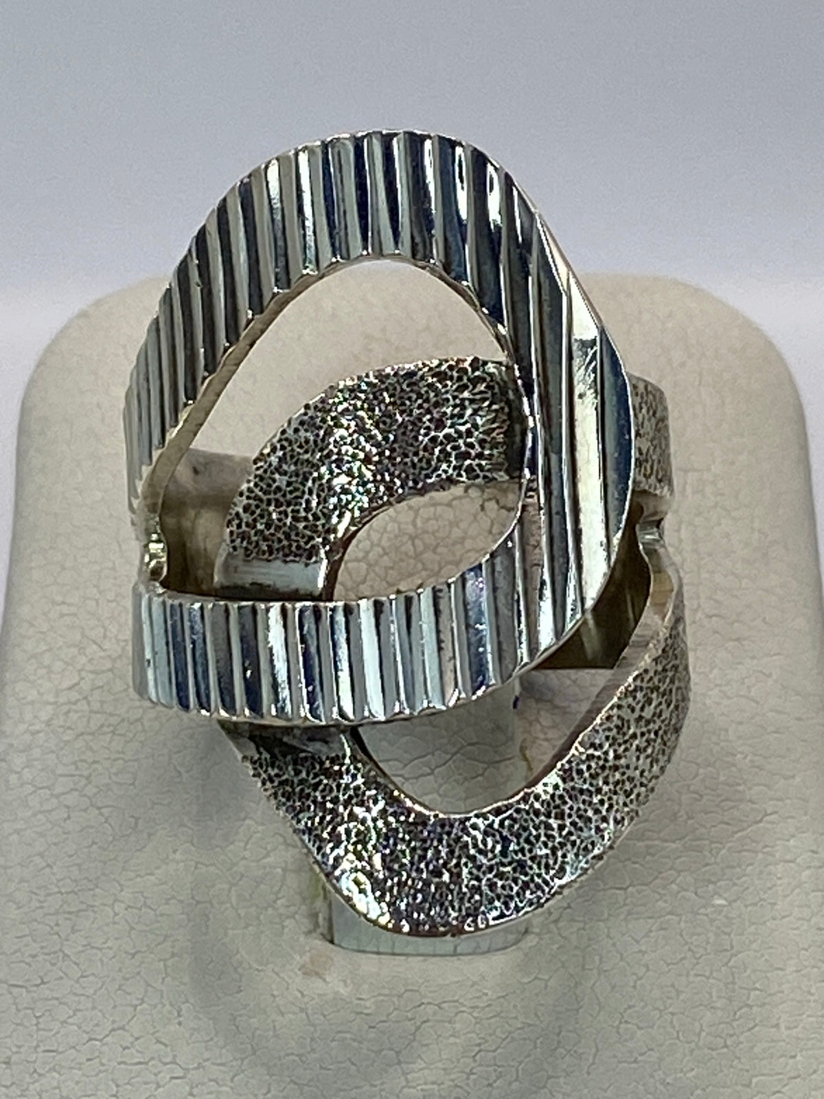 Anillo de plata 925 cartoneado con líneas volumétricas, vista frontal sobre fondo blanco