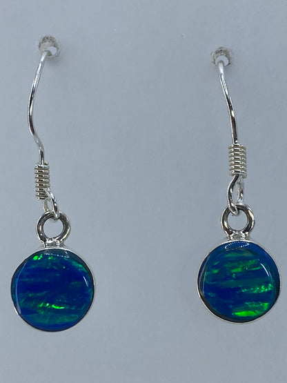 Aretes sobre regla de centímetros mostrando 2.7 cm de largo