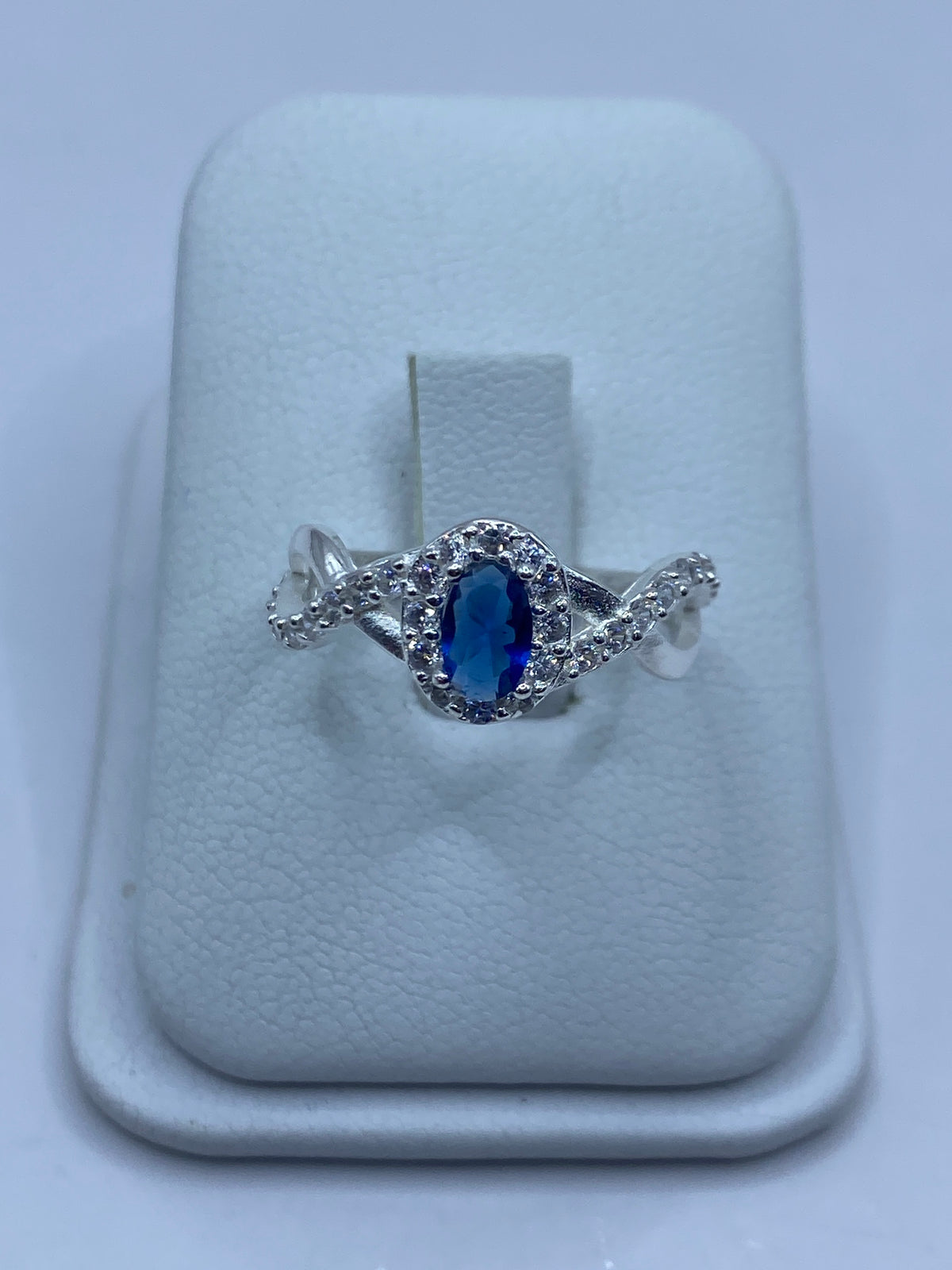 Anillo de plata 925 con circonia azul y micro-circonia blanca en tono brillante sobre soporte blanco