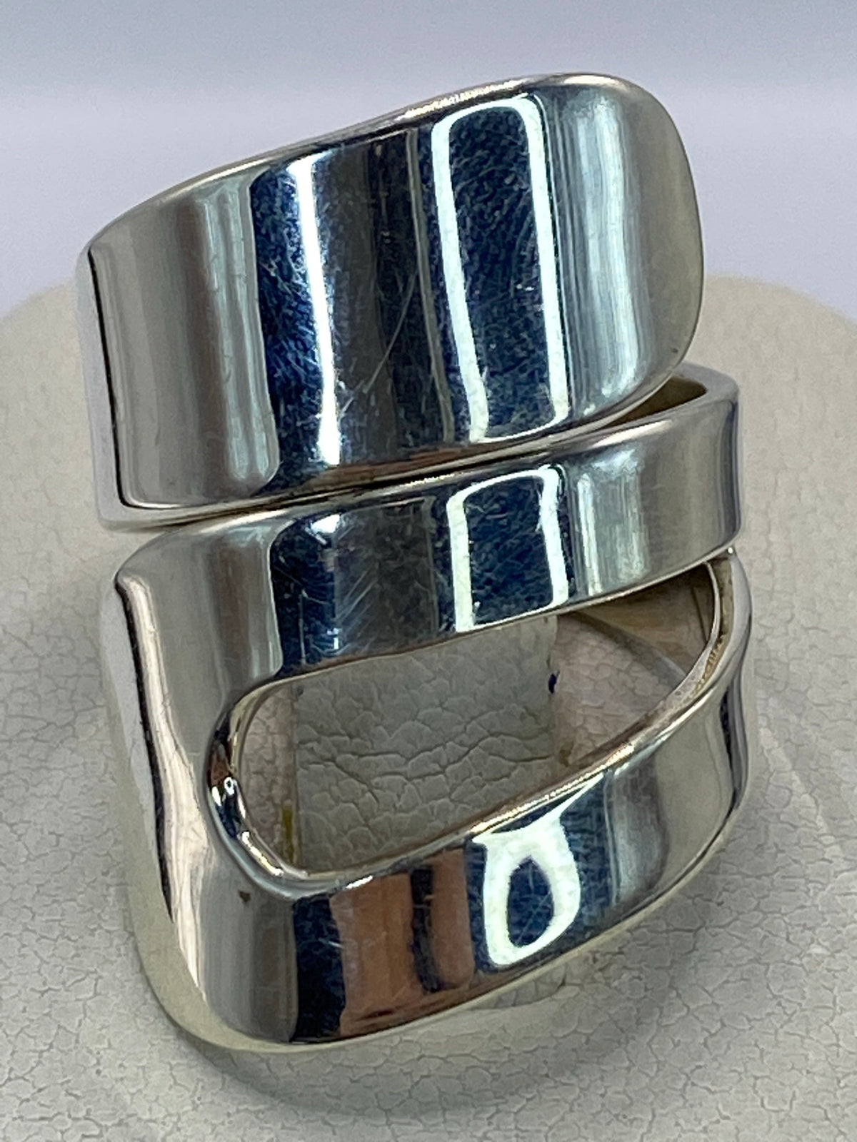 Anillo de plata cartoneado minimalista en talla 7 en la mano de una mujer