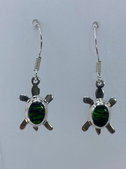 Detalle del ópalo de fuego verde engastado a mano en aretes de plata 925
