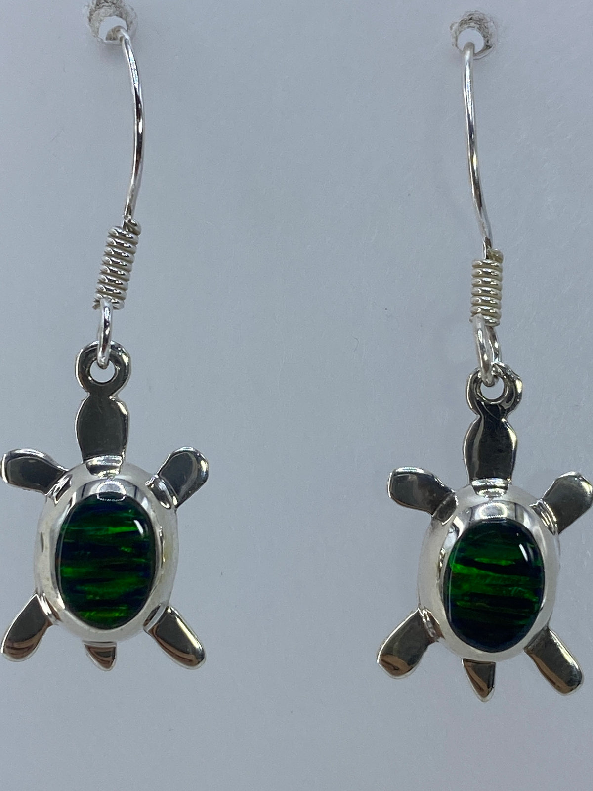 Aretes de tortuga sobre regla mostrando 3 cm de largo — vista frontal del par