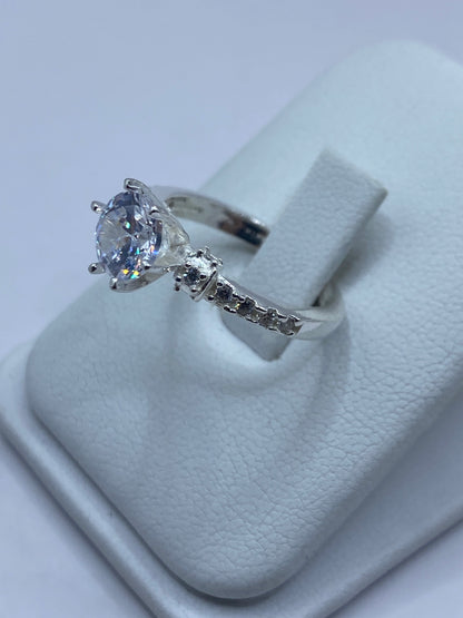 Anillo solitario en la mano de una mujer, mostrando la claridad de la piedra
