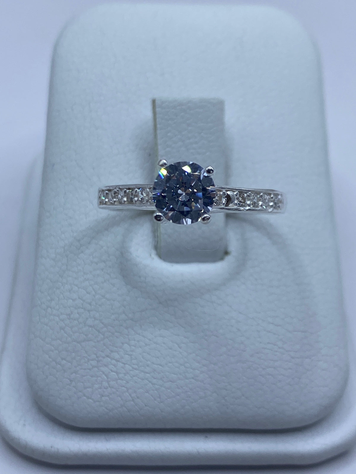 Anillo de plata solitario con circonia blanca engastada, vista frontal sobre dedo de mujer