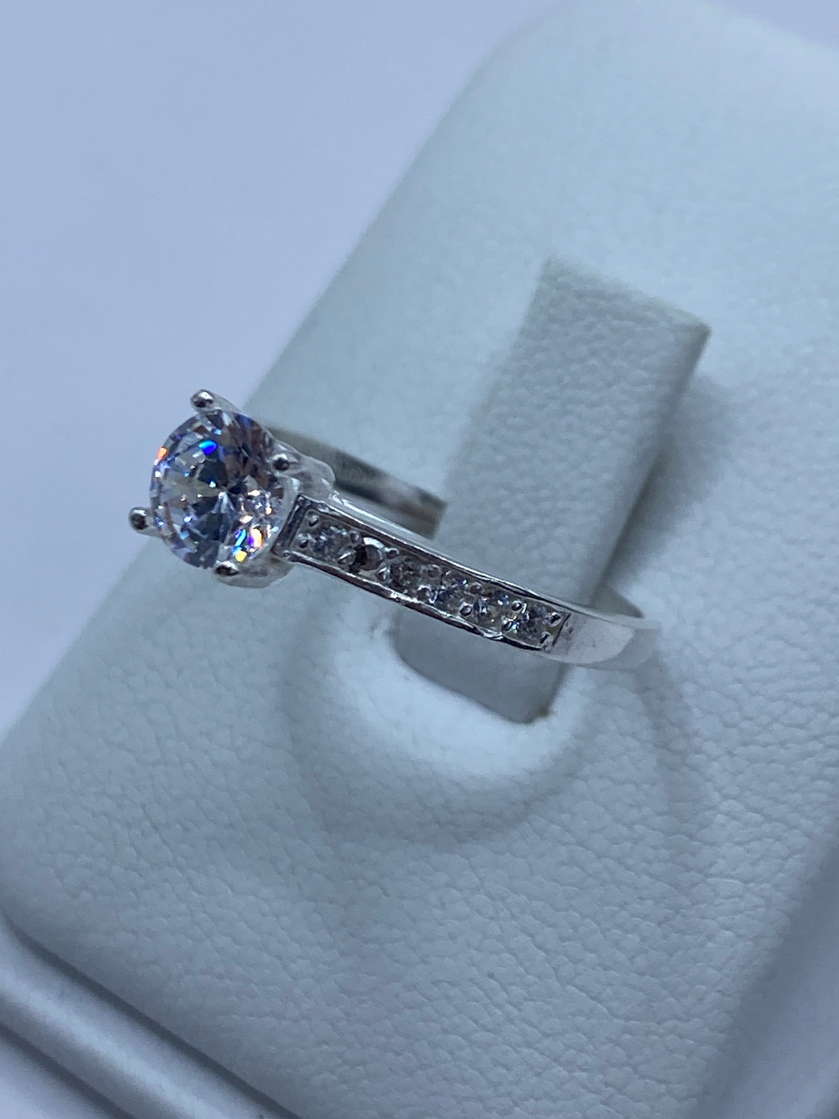 Vista lateral del anillo minimalista de plata con piedra blanca