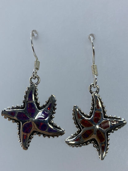 Pair of sterling silver starfish earrings with multicolor fire opal on white background