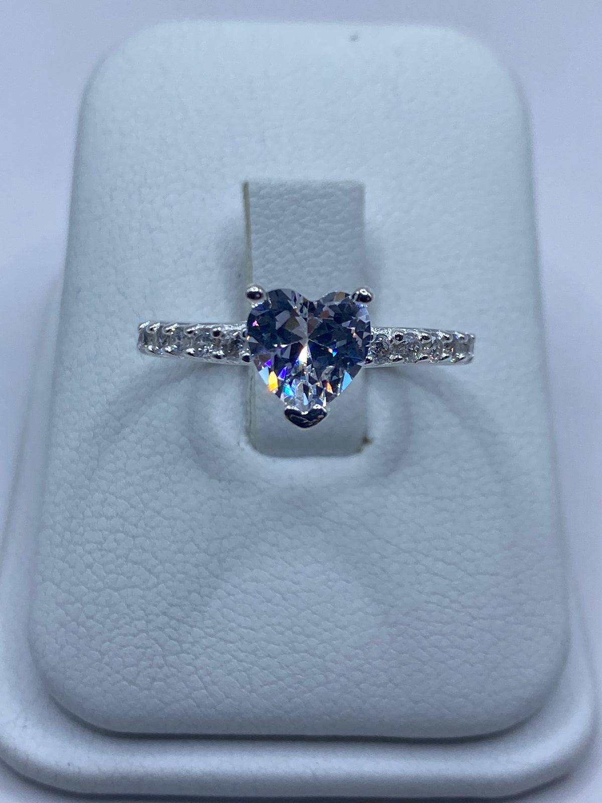 Anillo de plata solitario con circonia blanca en la mano de una mujer