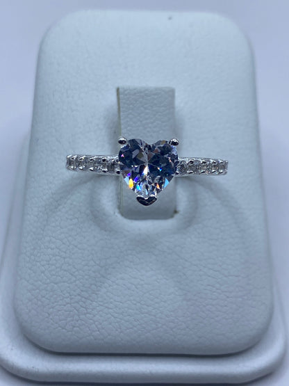 Anillo de plata solitario con circonia blanca en la mano de una mujer