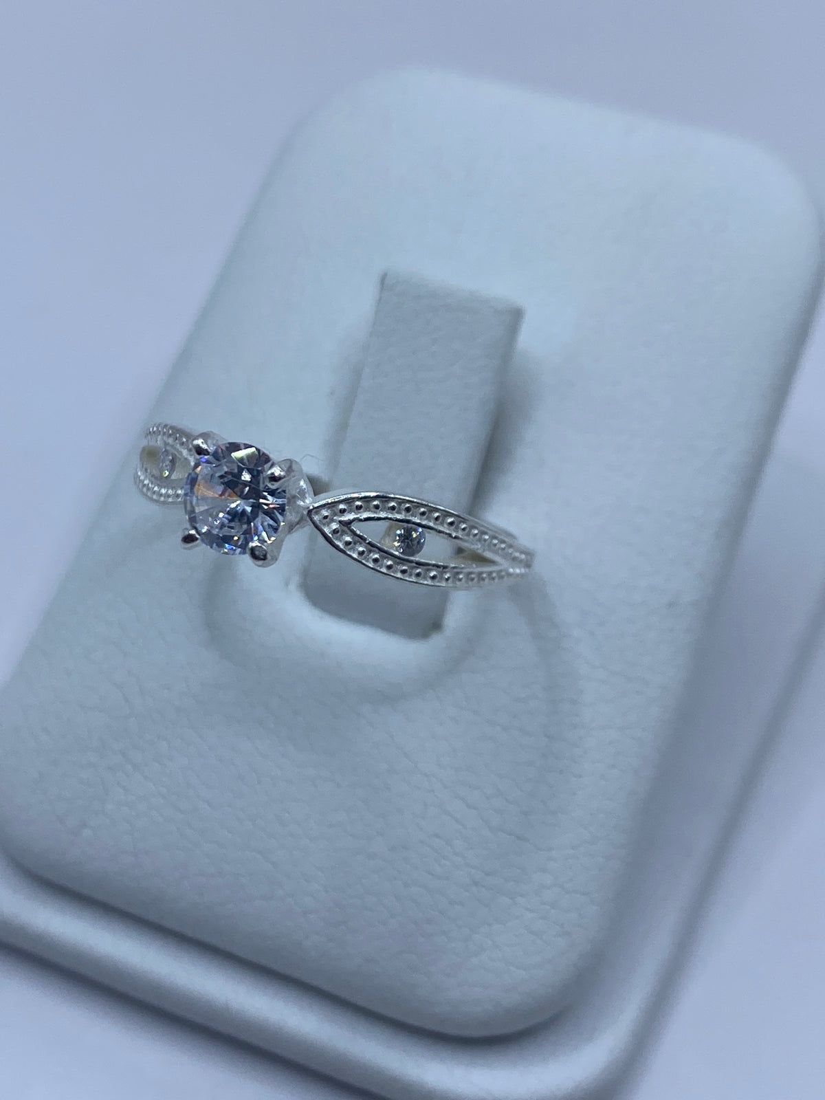 Vista frontal del anillo de circonia blanca engastada en plata pulida
