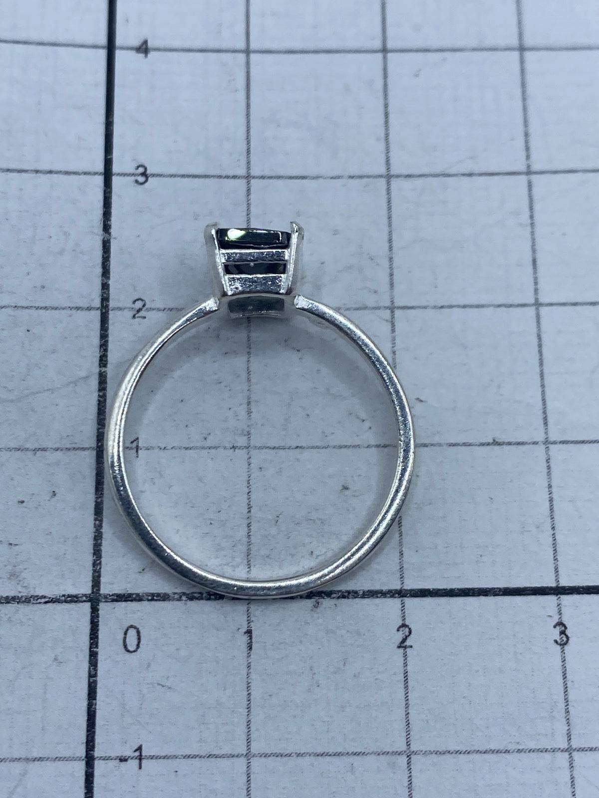 Anillo en mano sobre regla de medida, talla 7.5