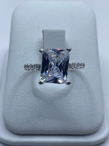 Anillo de plata solitario con circonia blanca rectangular en dedo de mujer