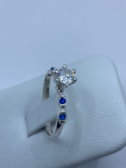 Anillo en la mano de una mujer con luz natural destacando el contraste blanco y azul