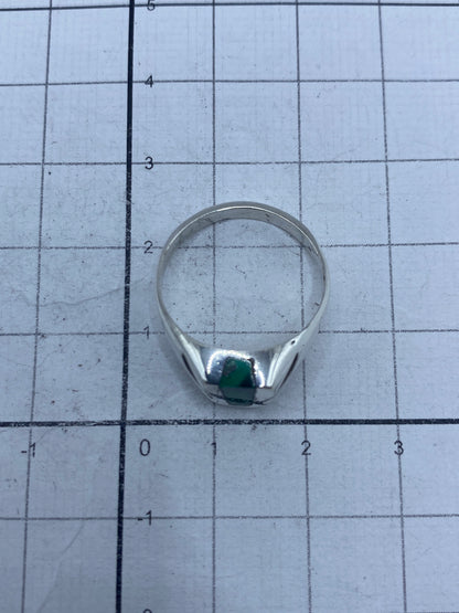 Anillo sobre fondo blanco destacando el color verde profundo de la piedra