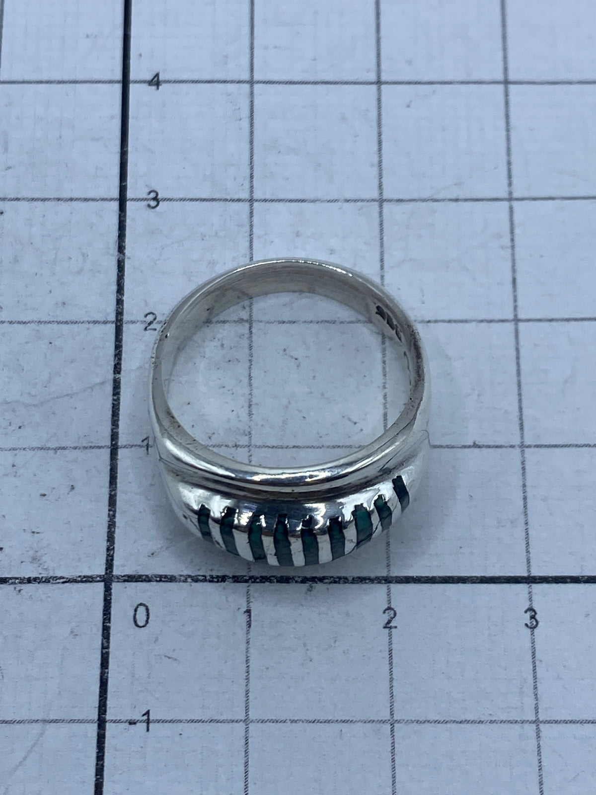 Anillo sobre fondo gris mostrando grabado del Quinto 925 en el interior
