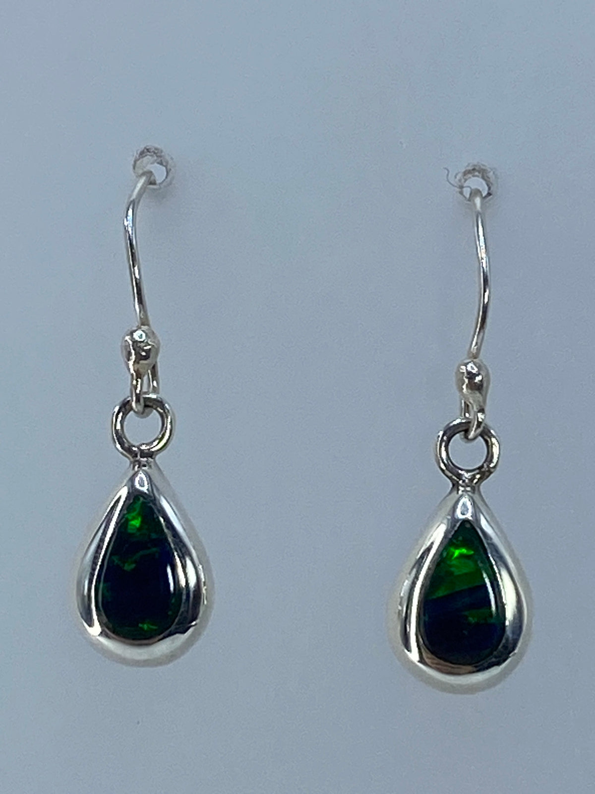 Aretes de plata 925 con ópalo de fuego verde engastado, vista de frente del par completo
