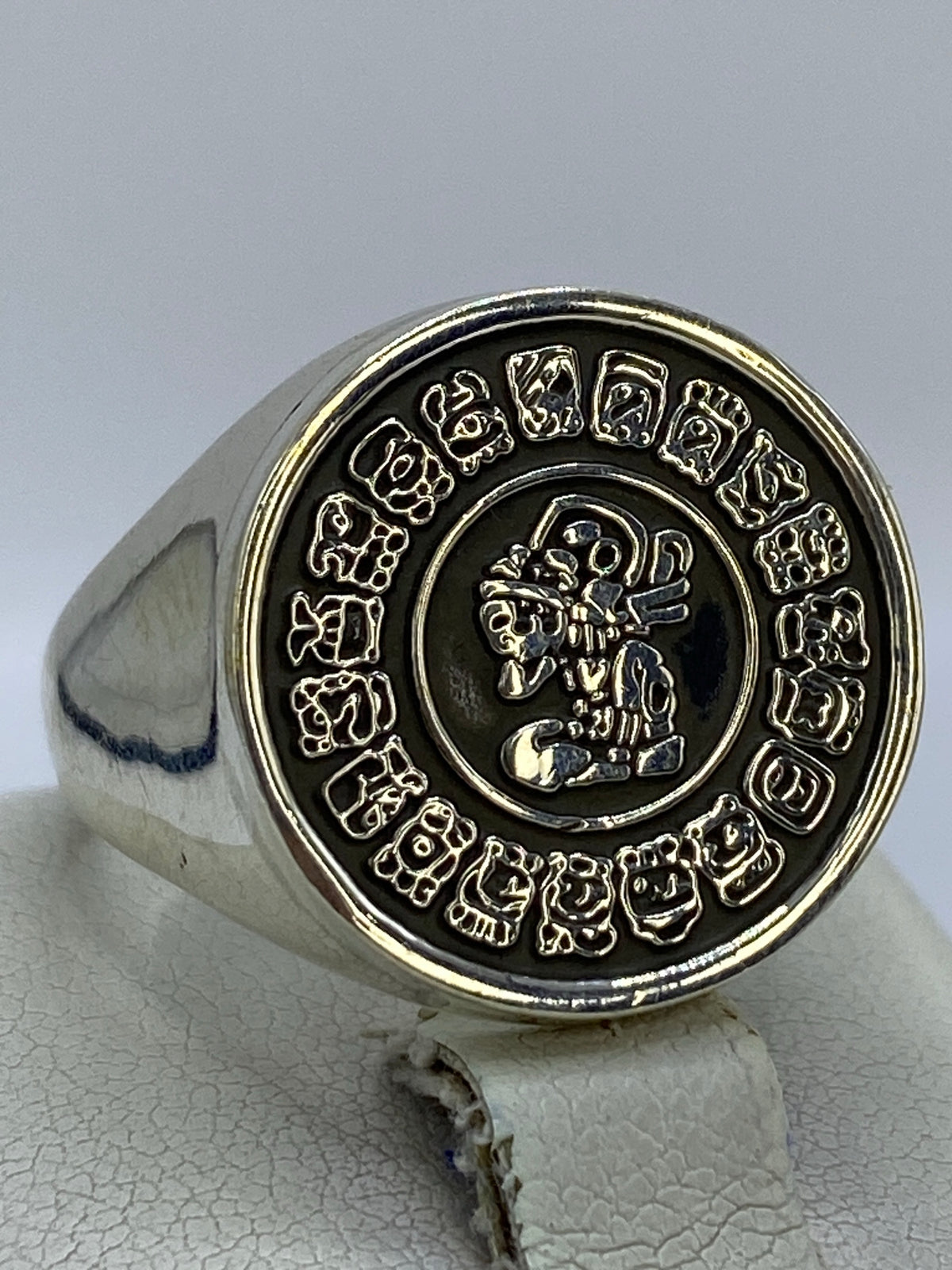 Detalle del anillo mostrando el relieve profundo del repujado y los glifos del calendario