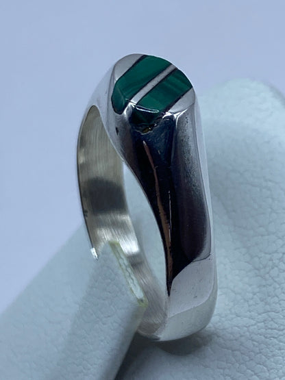 Anillo de plata con malaquita verde en la mano, mostrando el color natural