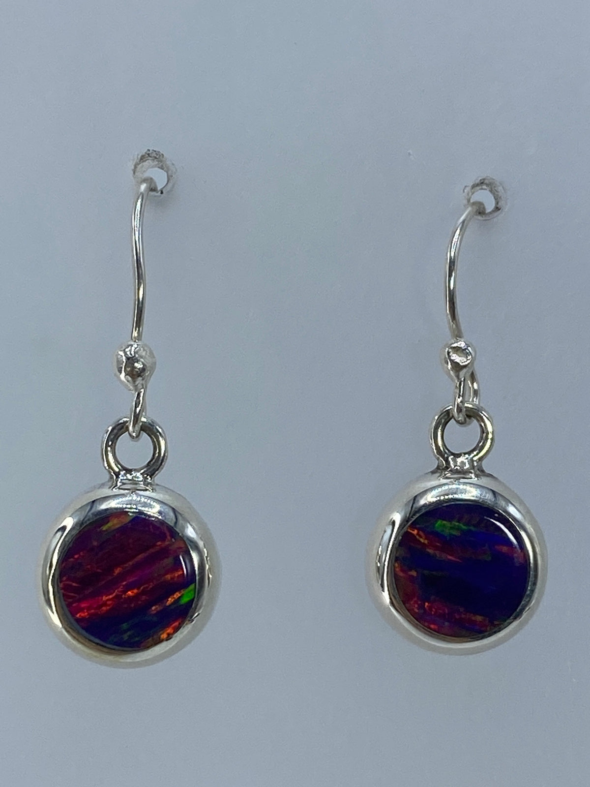 Par de aretes de plata 950 con ópalo de fuego rojo brillante, colgando en vista frontal