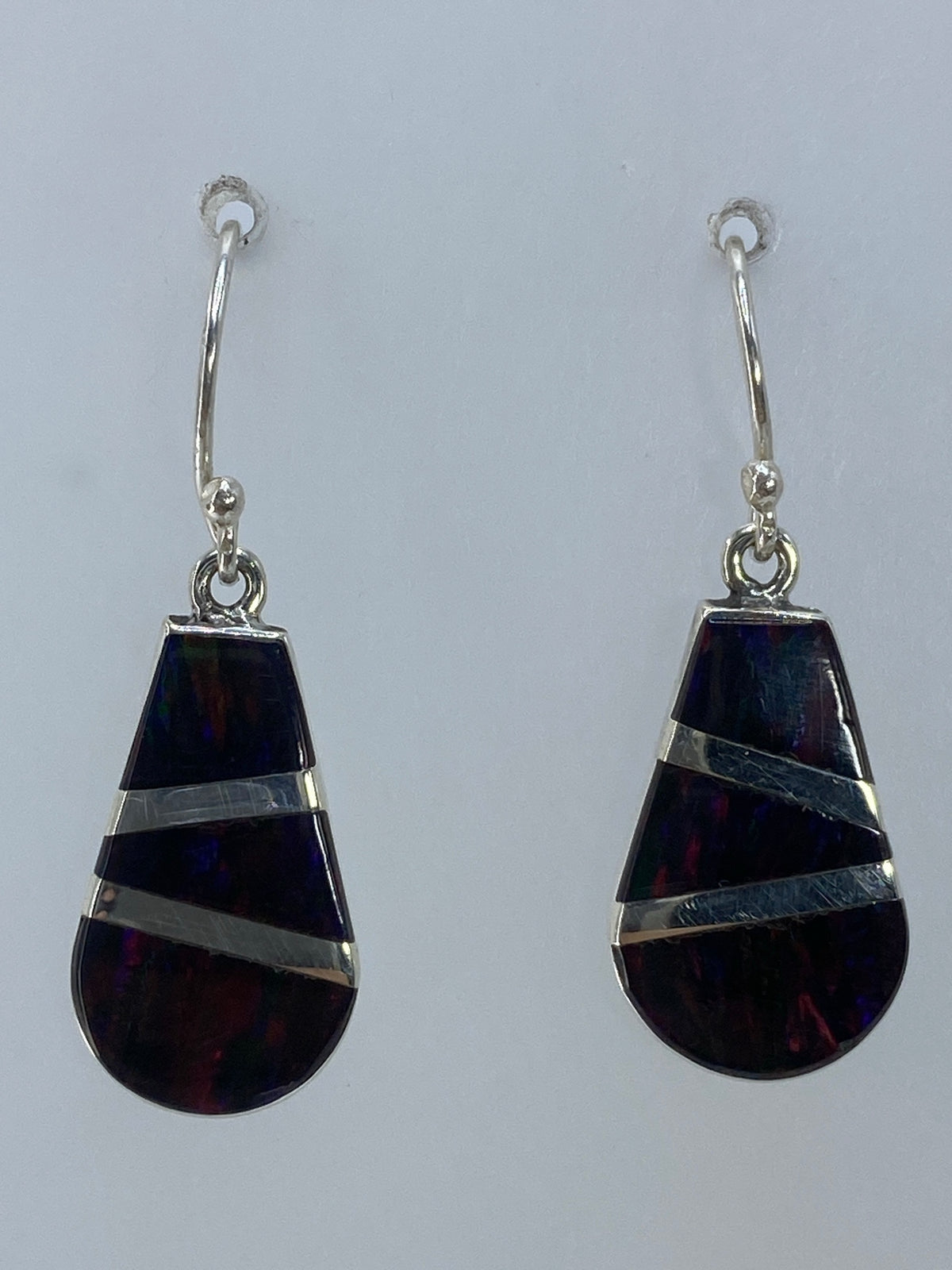 Par de aretes de plata 950 con ópalo de fuego multicolor, caídos en forma de gota sobre fondo blanco