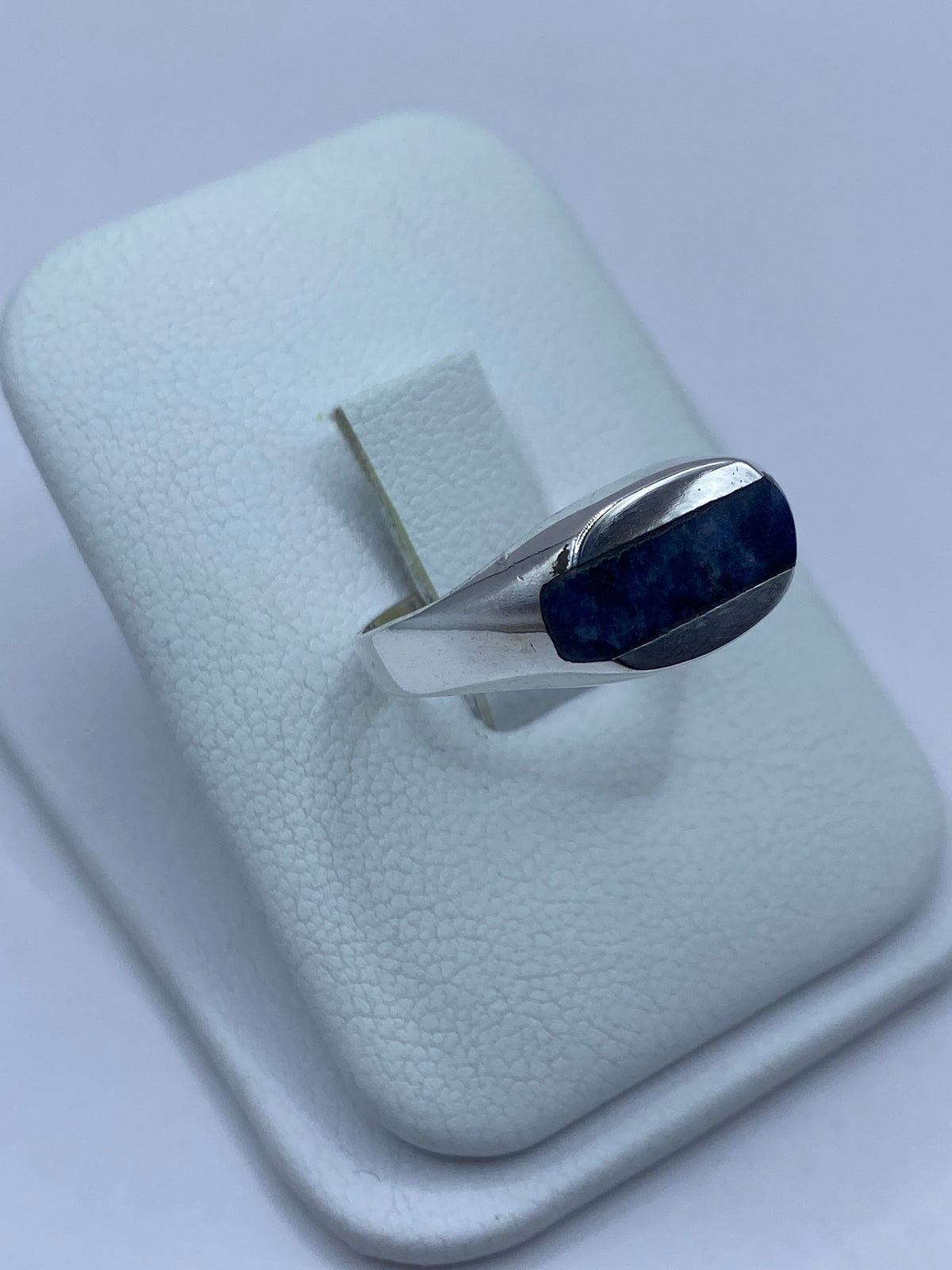 Detalle lateral del anillo mostrando el engaste a mano y el pulido de la plata