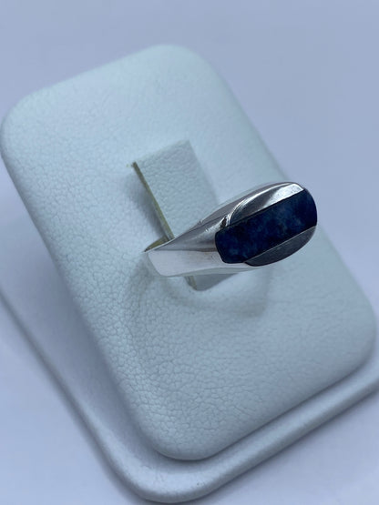 Detalle lateral del anillo mostrando el engaste a mano y el pulido de la plata