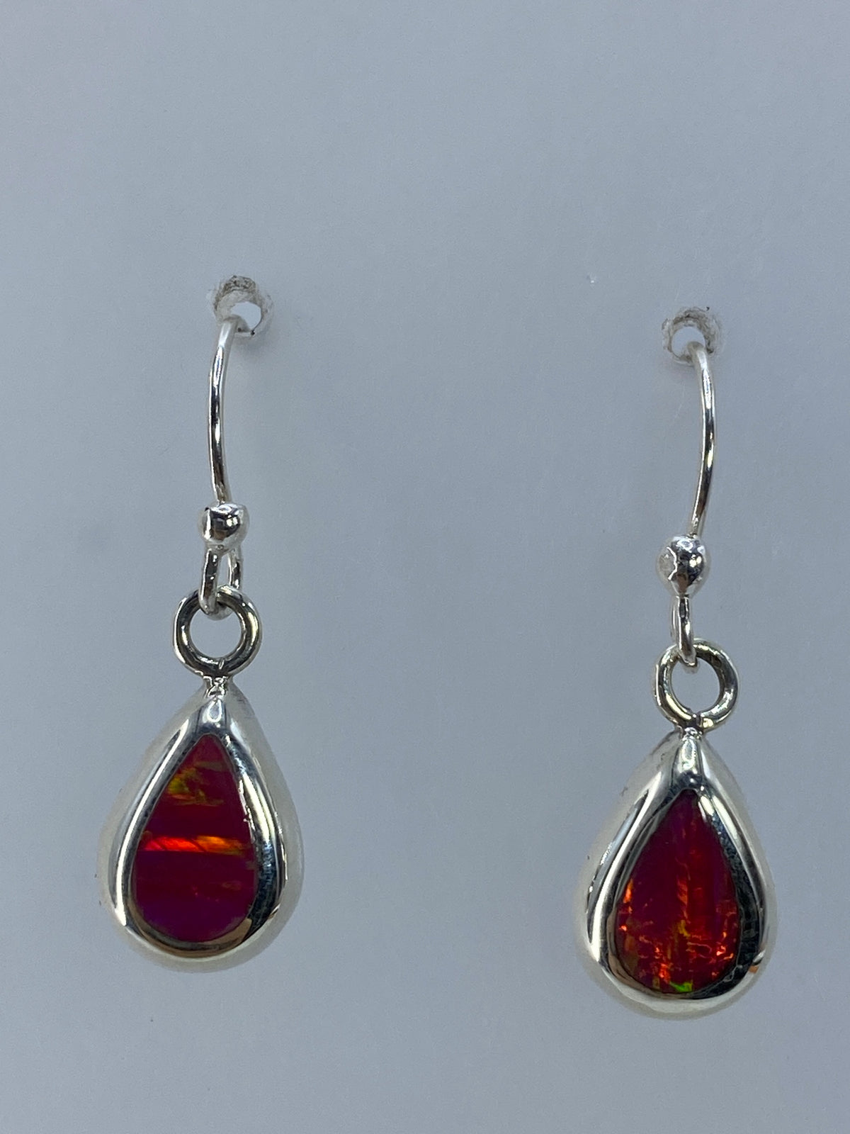 Aretes de plata con ópalo de fuego rosa, de 2.5 cm de largo, vista frontal