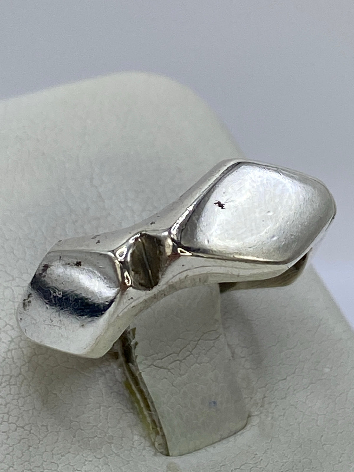 Detalle lateral del anillo mostrando la profundidad del repujado y el acabado pulido