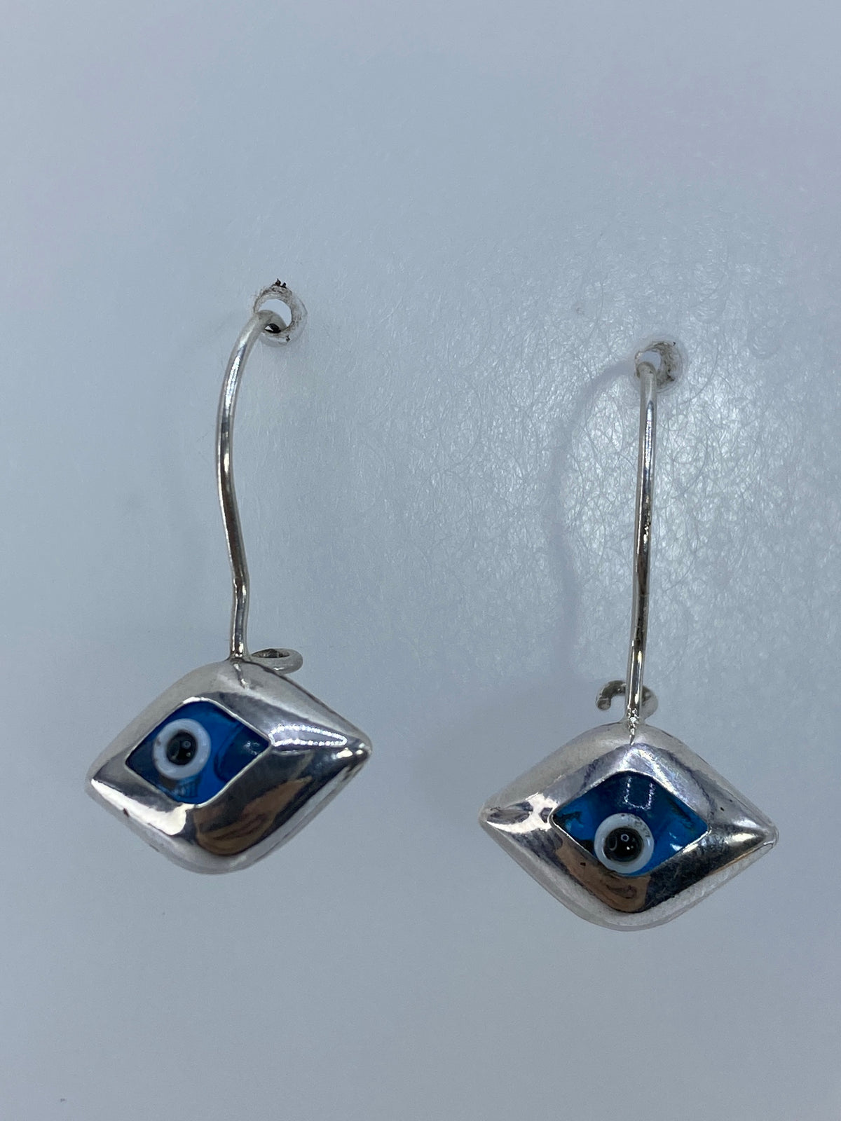 Detalle del ojo azul cielo incrustado en plata 925, visto de frente