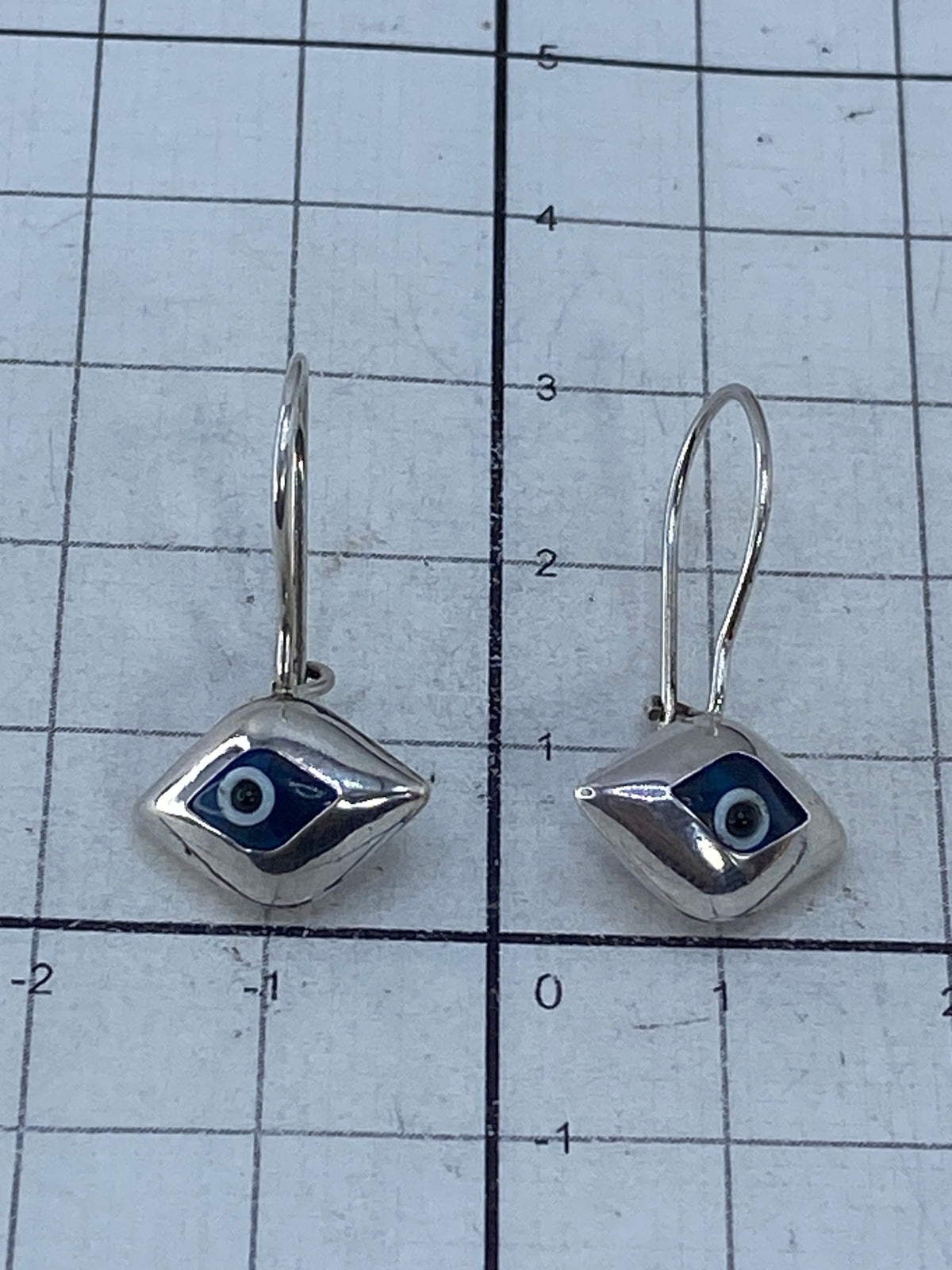 Vista del reverso de los aretes mostrando la incrustación y el gancho de plata