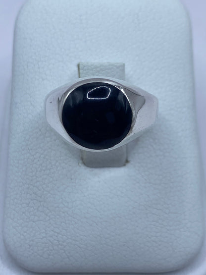 Anillo de plata con ónix negro engastado, vista frontal sobre dedo