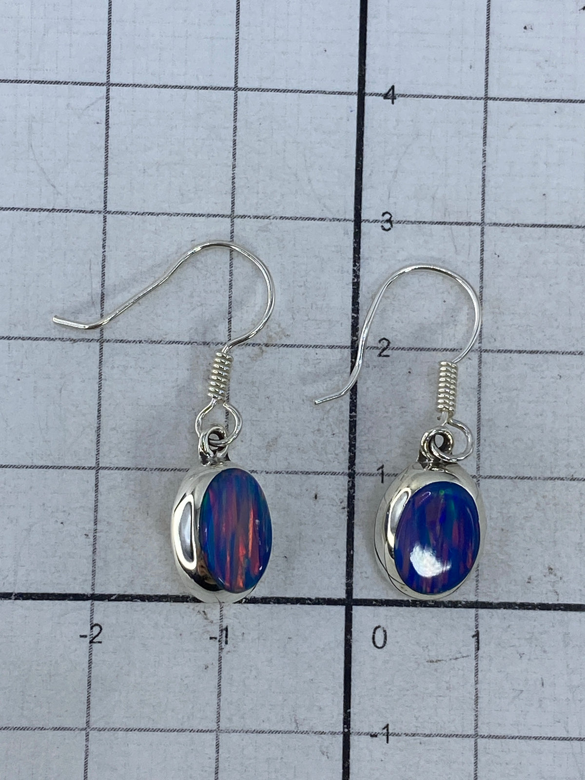 Aretes sobre medidor de escala — detalle del tamaño real 2.8 cm
