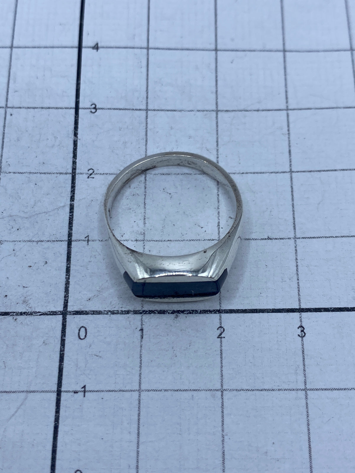 Anillo de plata con lapislázuli azul visto desde arriba sobre escala de medida