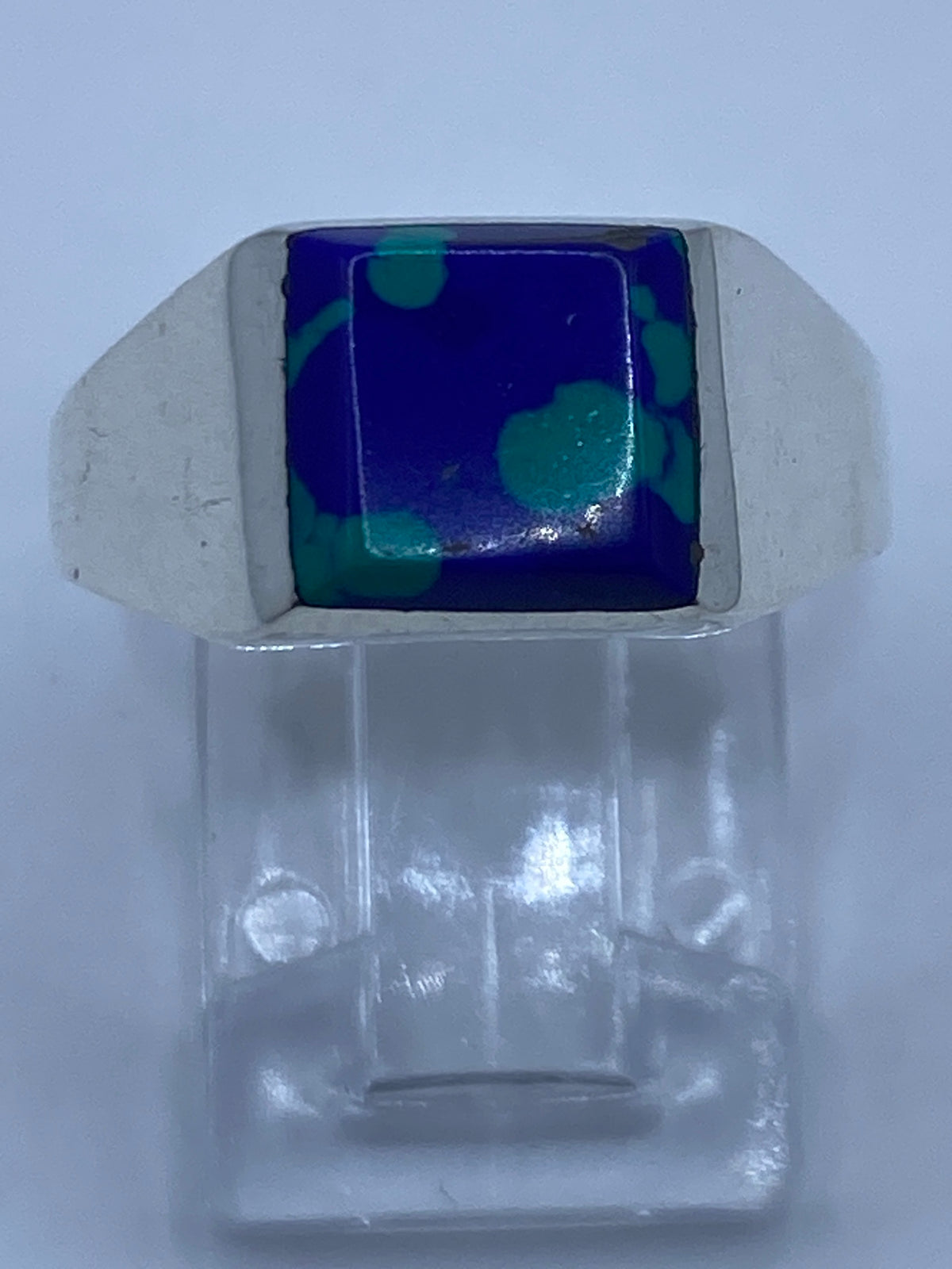 Anillo de plata 925 con piedra azul engastada en la mano de una persona