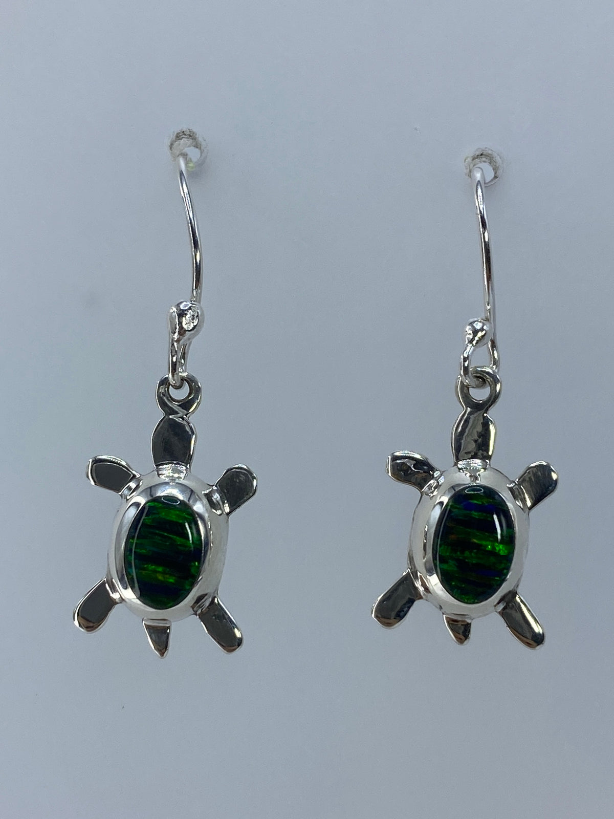 Detalle de engaste a mano del ópalo de fuego en la tortuga de plata