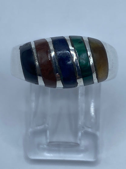 Anillo de plata con cuatro piedras: malaquita verde, lapislázuli azul, ojo de gato café y ónix negra