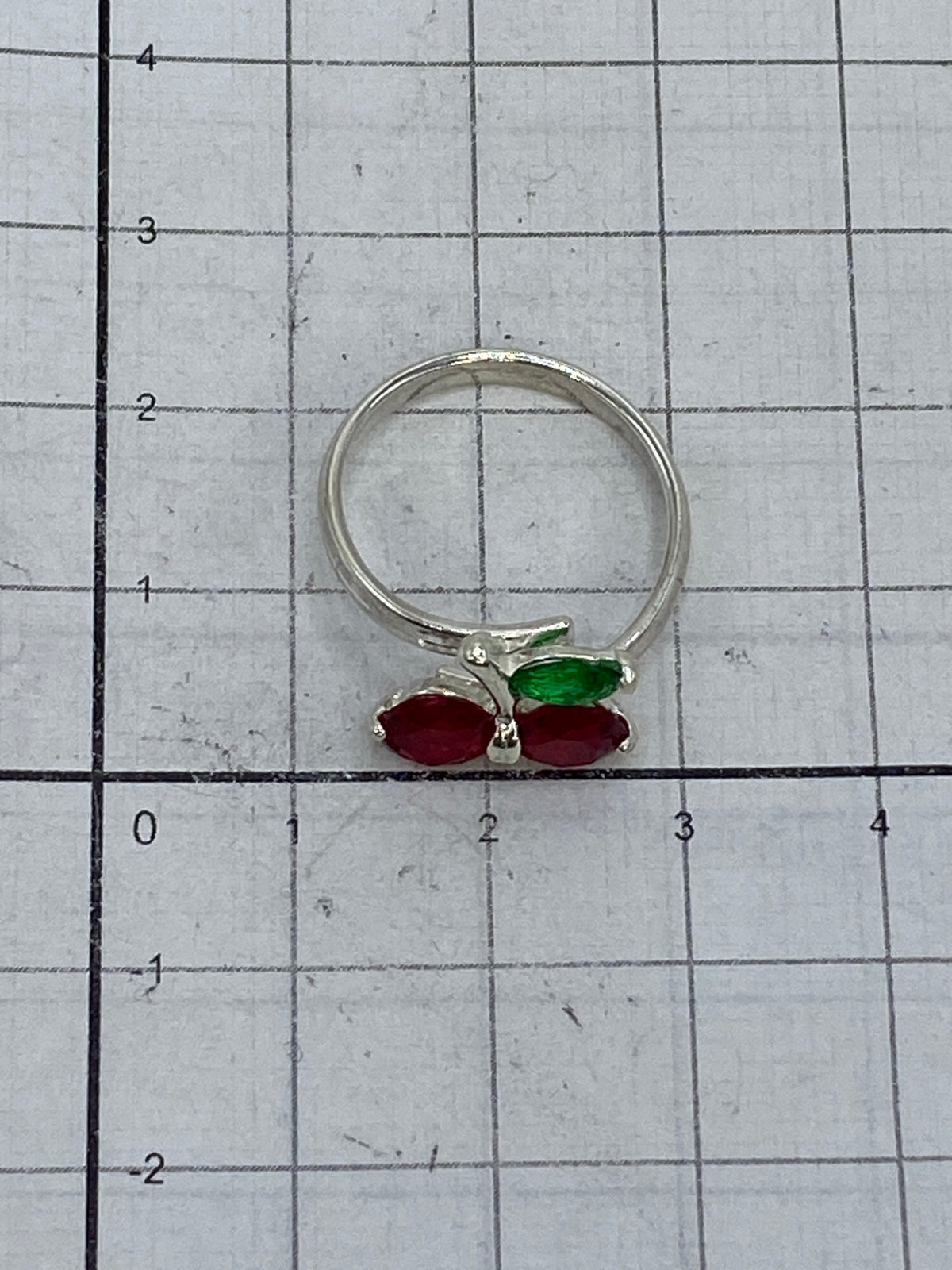 Anillo cereza en la mano mostrando el brillo y fuego de las circonia rojas