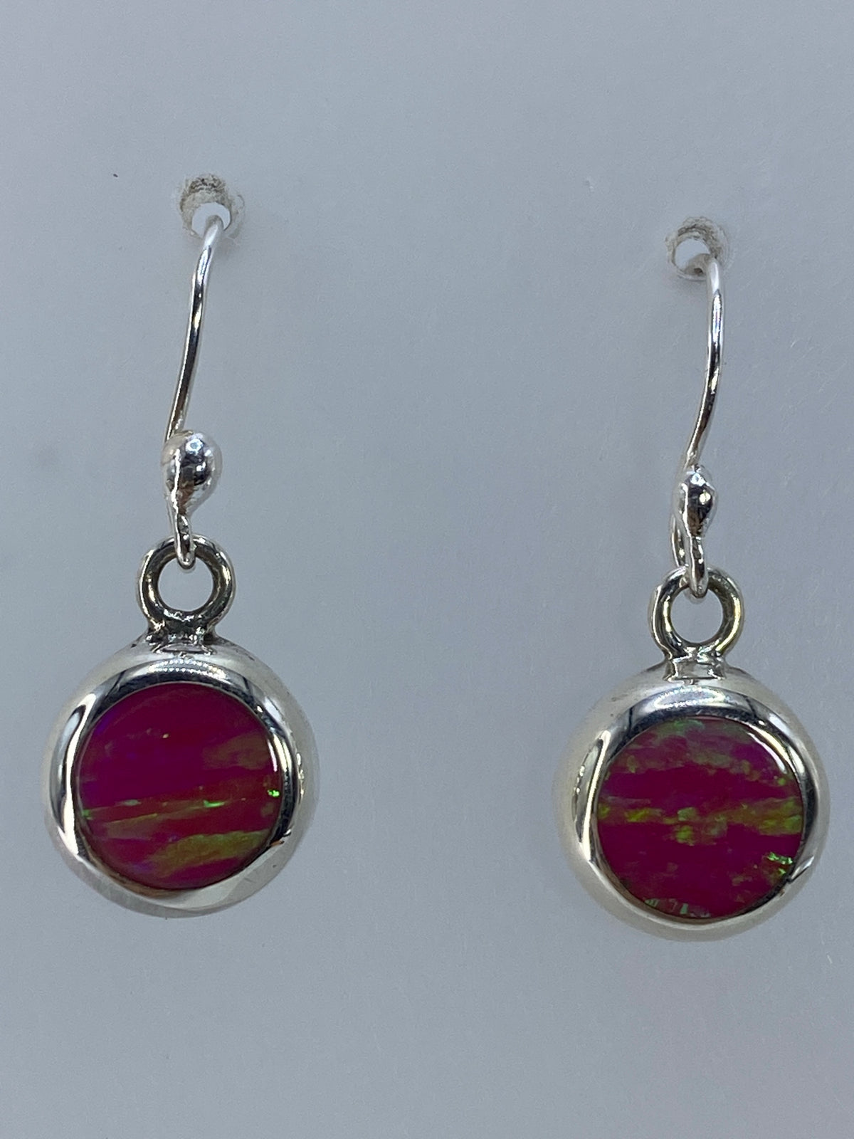 Aretes de plata con ópalo de fuego verde olivo, vistos de frente