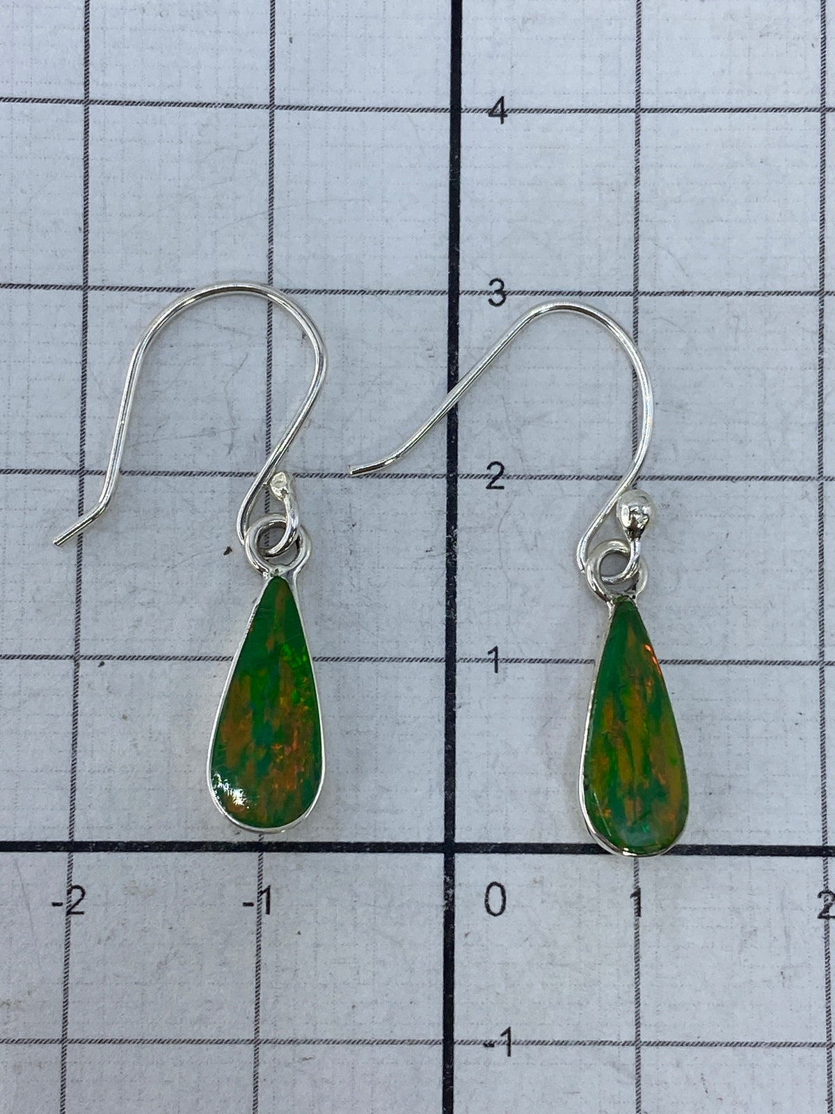 Aretes sobre fondo blanco, midiendo 3 cm de largo — vista de frente