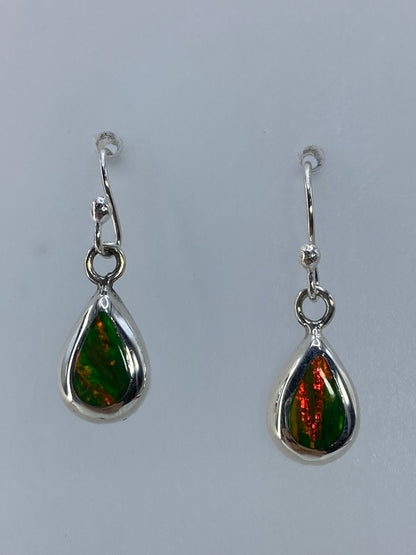 Detalle de un arete mostrando el color naranja del ópalo de fuego y el engaste de plata 925
