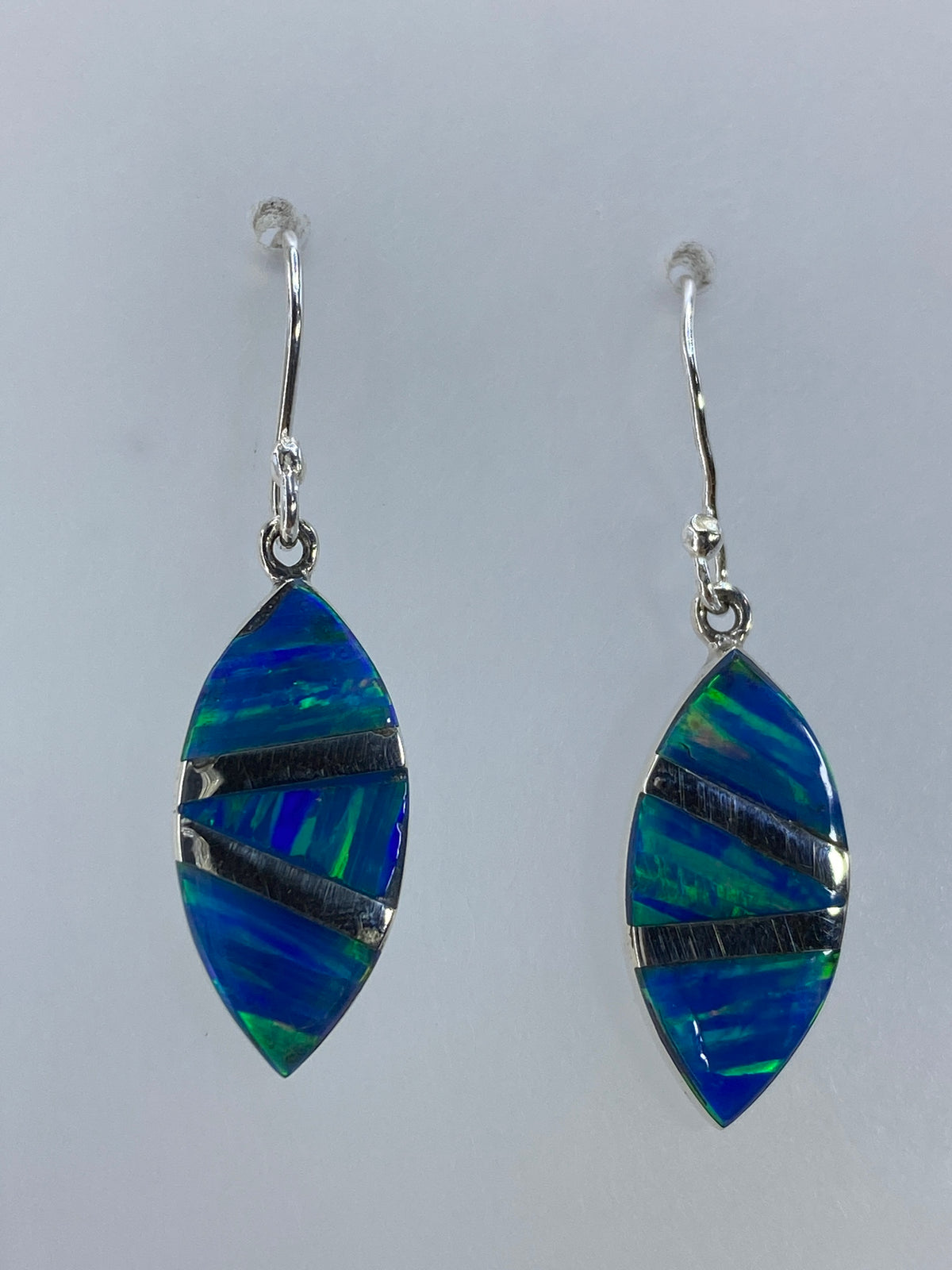 Aretes de plata 950 mostrando el verde olivo del ópalo de fuego con destellos internos