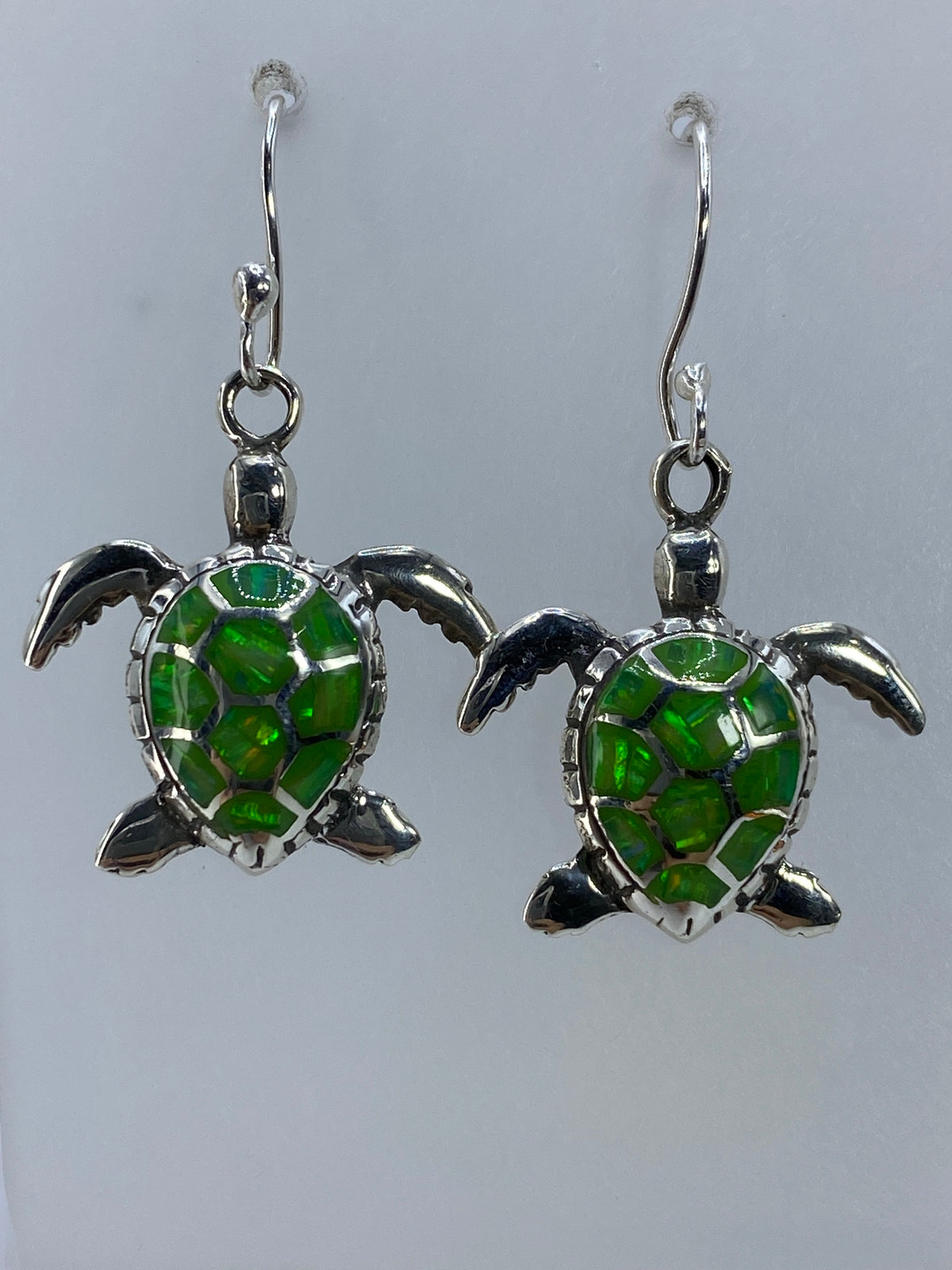 Arete de tortuga de plata 950 mostrando detalle del caparazón y piedra verde
