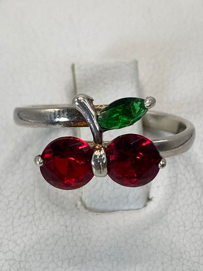 Anillo de plata solitario con circonia roja facetada en la mano de una mujer