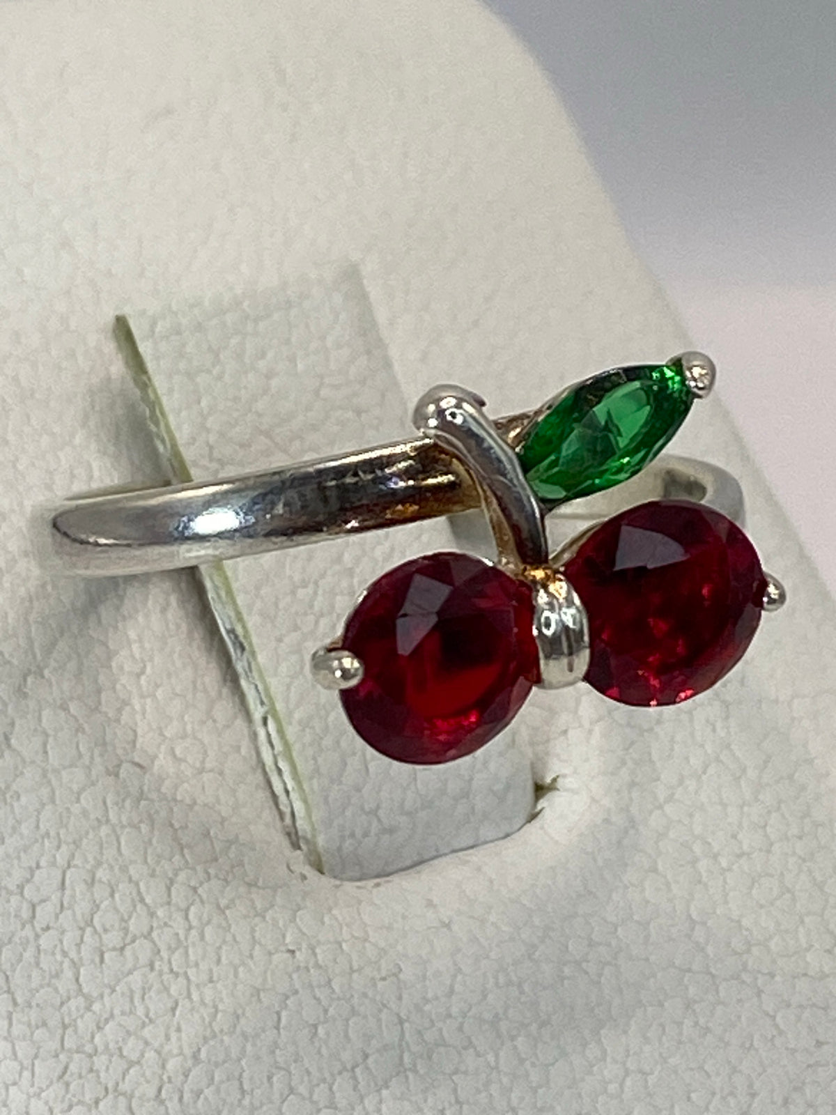 Vista frontal del anillo mostrando la circonia roja brillante en plata 925