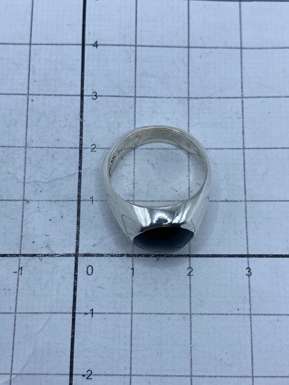 Anillo sobre balanza mostrando peso de 7.1 gramos y sello de autenticidad