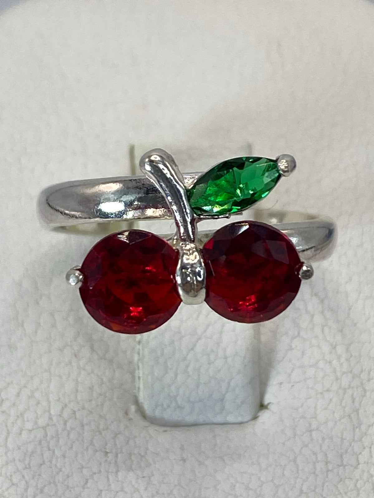 Anillo puesto en dedo, mostrando el brillo de la circonia roja