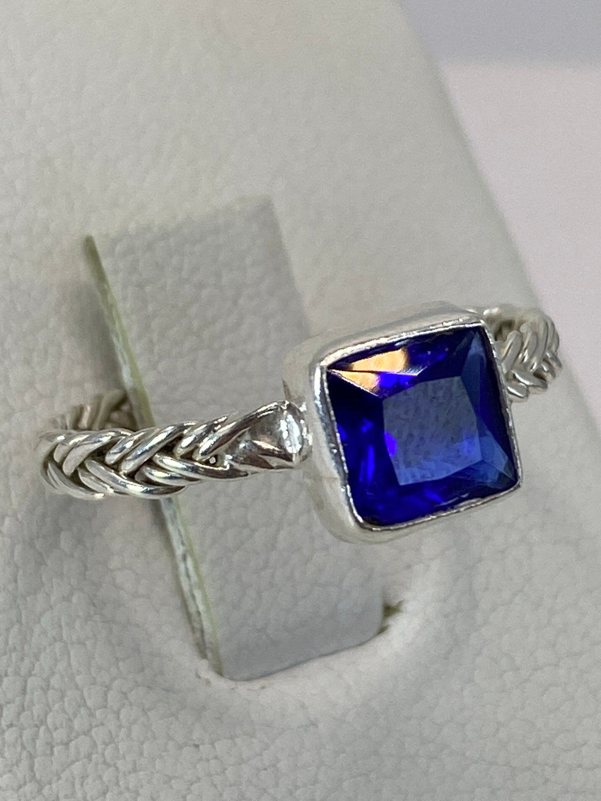 Vista frontal del anillo mostrando la circonia azul con brillo intenso