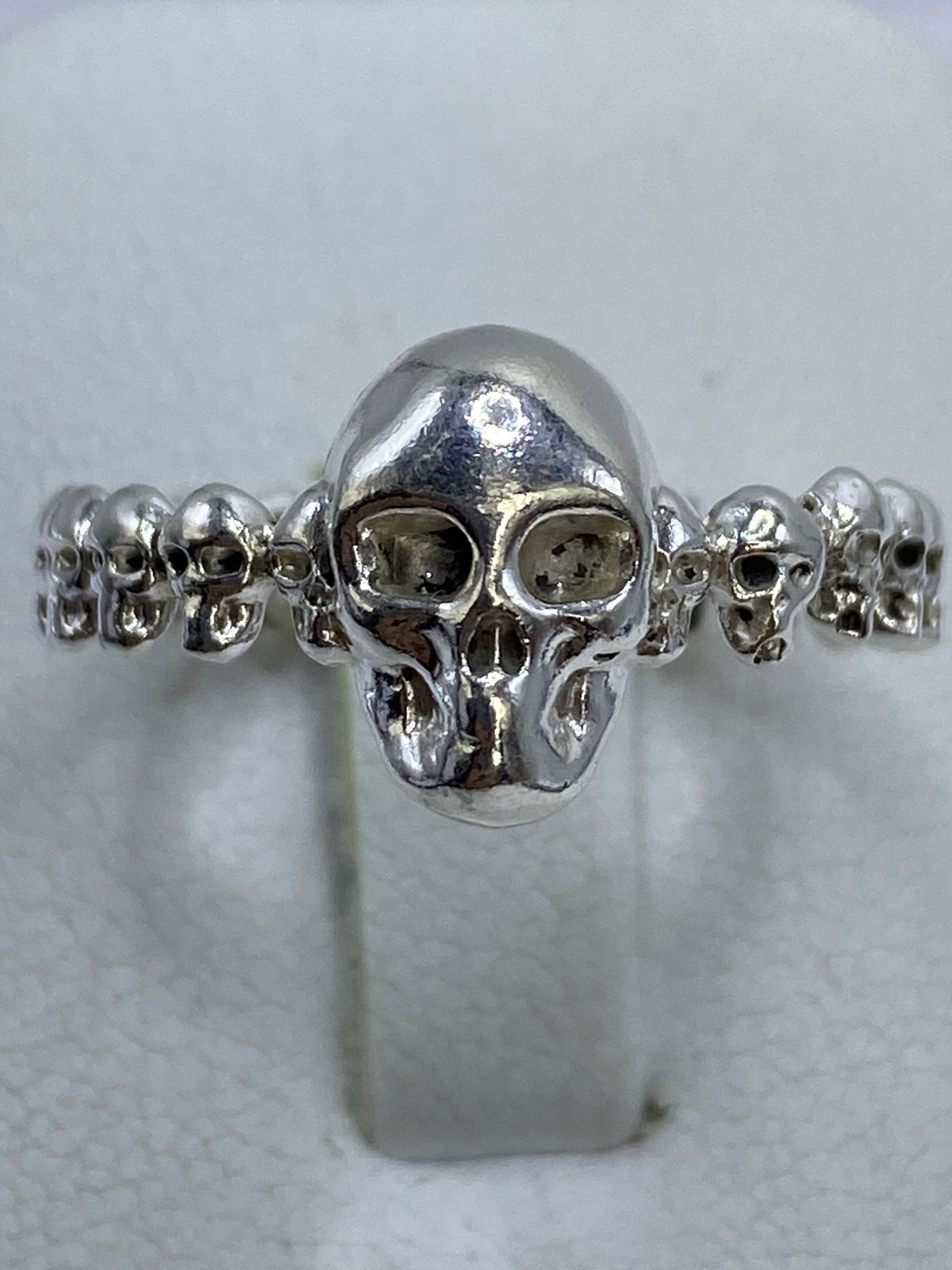 Anillo de calavera en mano de mujer, mostrando el acabado pulido