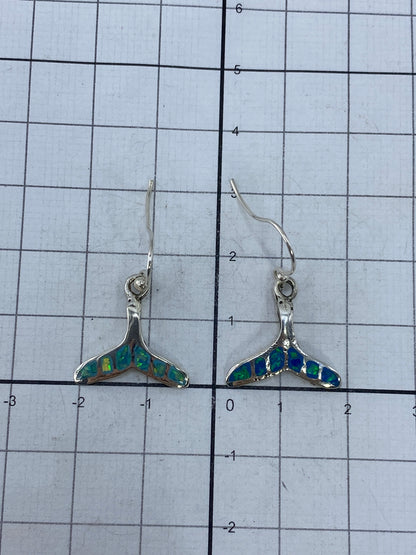 Aretes de ópalo en la mano, mostrando tamaño y peso (3 cm de largo)