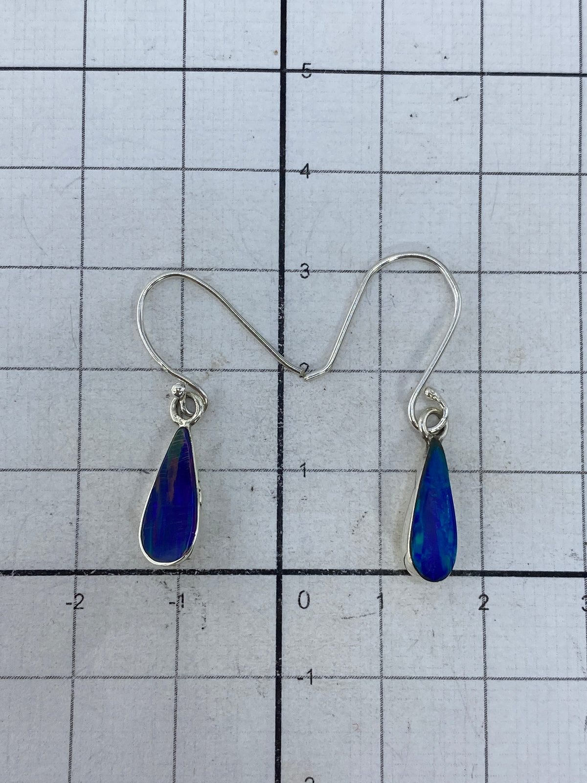 Detalle del engaste de plata y la piedra de ópalo multicolor en cada arete